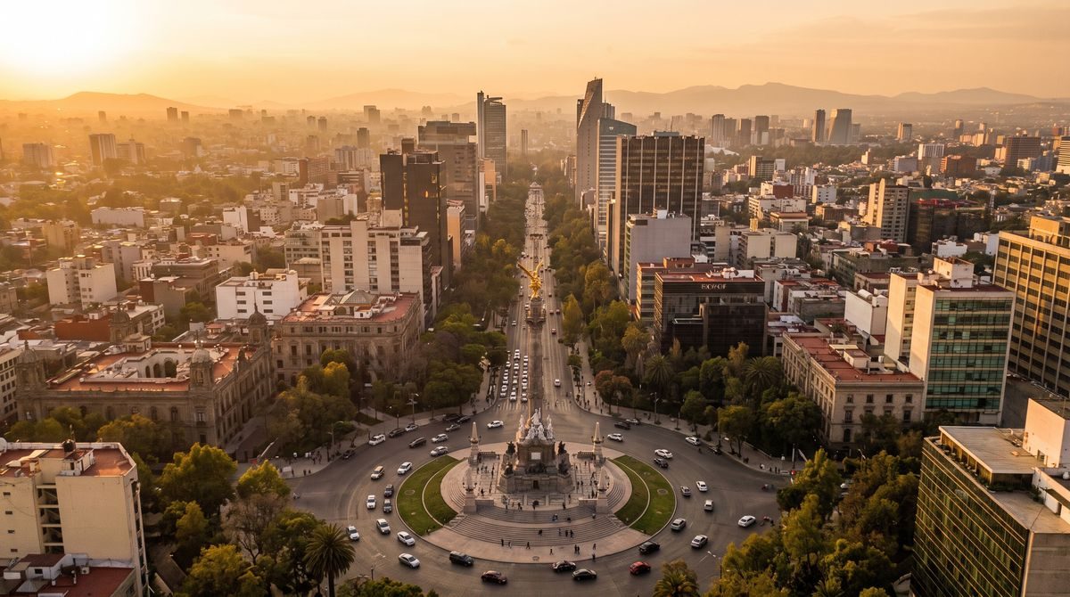 Aerial view of Mexico City with the Angel of Independence monument and Paseo de la Reforma at dusk