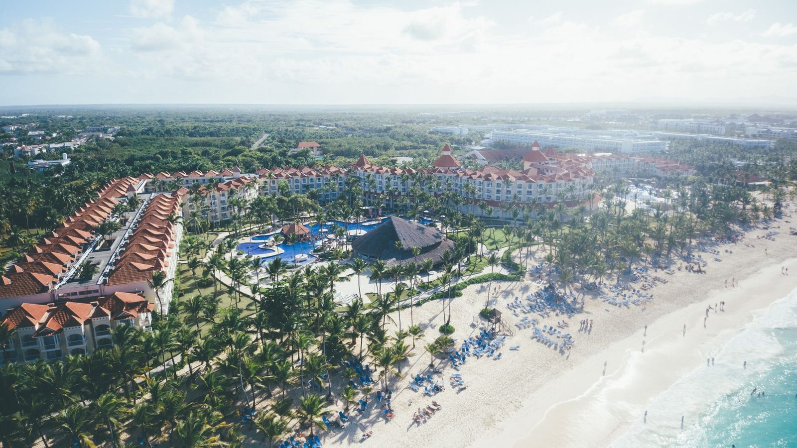 Aerial shot of a tropical beach resort in Punta Cana with palm trees and ocean views.