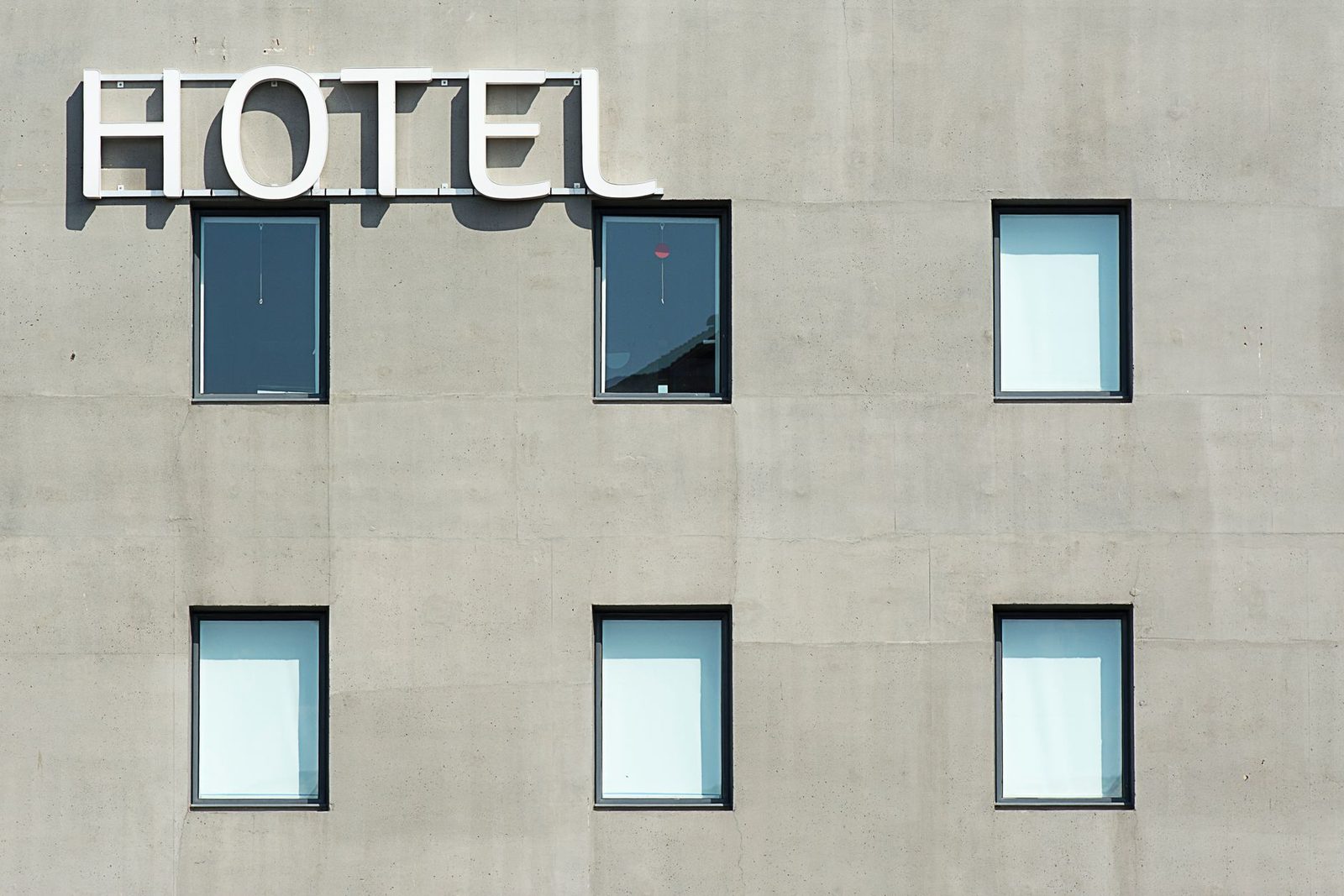 Contemporary hotel facade featuring minimalist design and geometric window patterns.