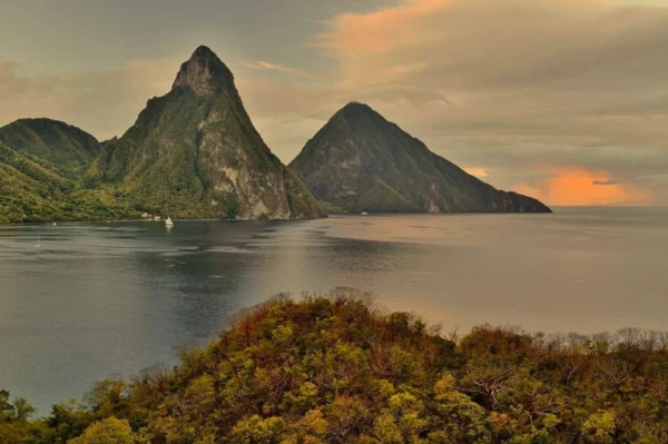 Sunset view of two steep mountains over calm water: Cheapest Months to Book an All-Inclusive Resort in 2026