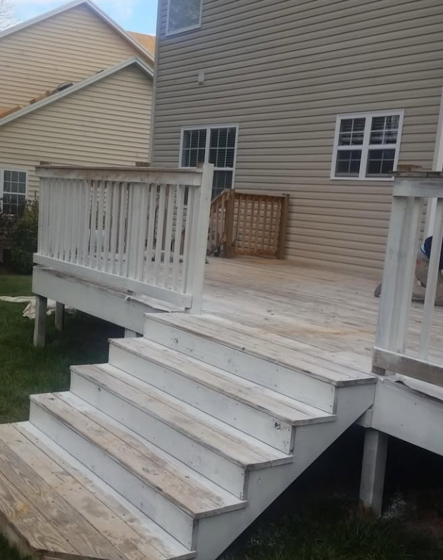 A weathered gray deck and siding before cleaning and refinishing