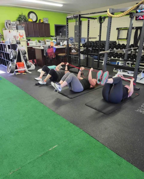 Woman strength training with a personal trainer at Health Targeted Solutions